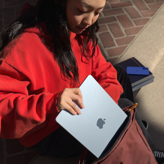 Uno studente che infila il suo MacBook Air nello zaino